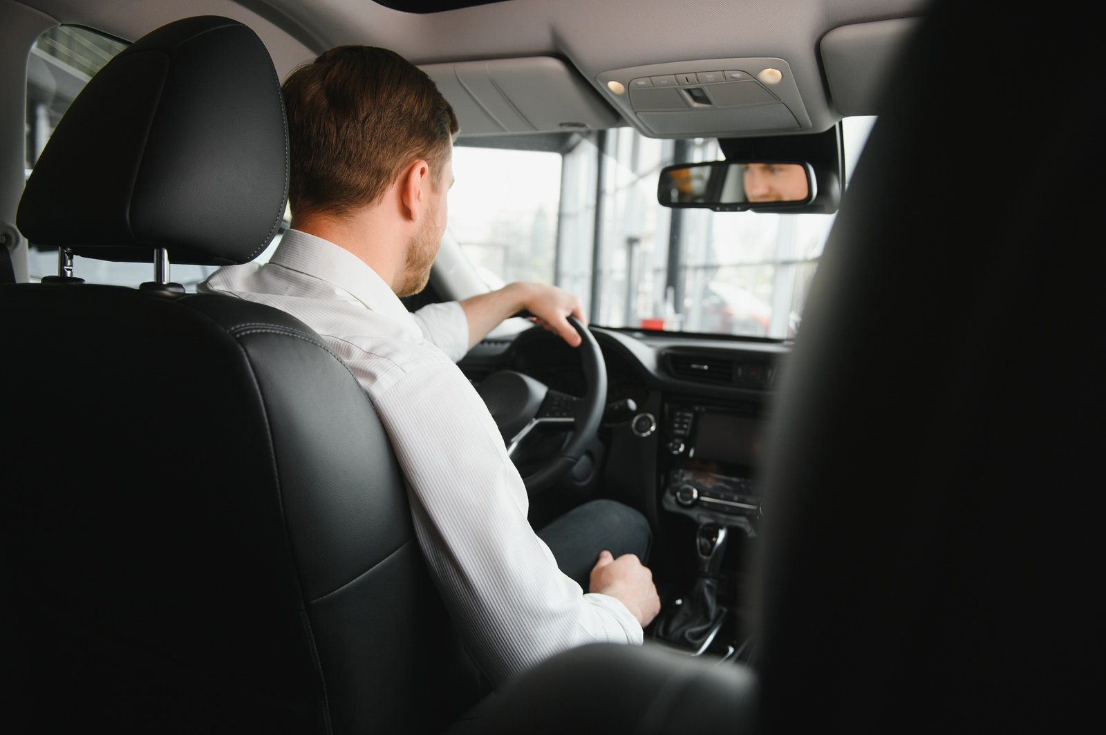 Portrait of a handsome male chauffeur sitting in a car