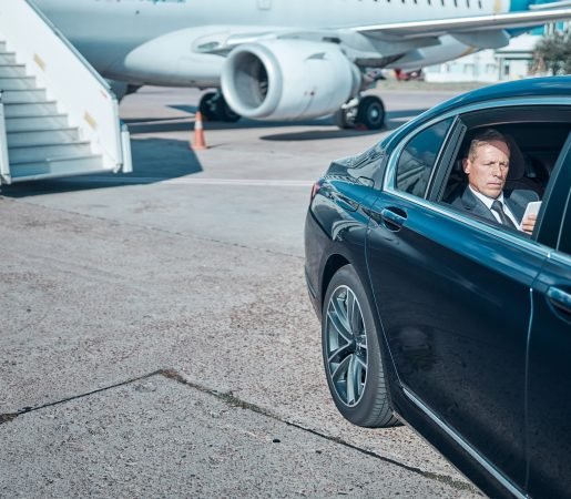Businessman with smartphone in car at airport Businessman with smartphone in car at airport